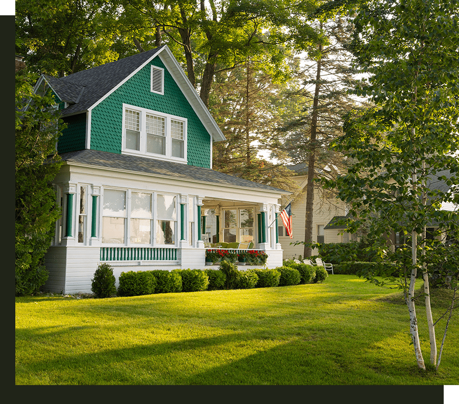 Green house with porch and American flag